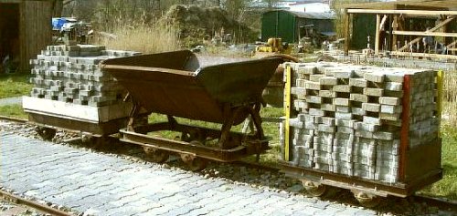 2 Flachwagen mit Pflastersteinen und eine Kipplore